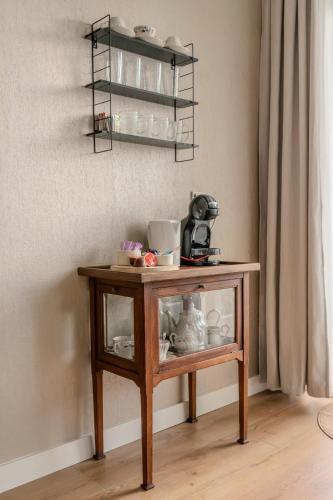 a small wooden table with dishes on a wall at City apartment in the centre of Enschede in Enschede