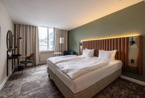 a hotel room with a large bed and a window at Imperial Hotel in Copenhagen