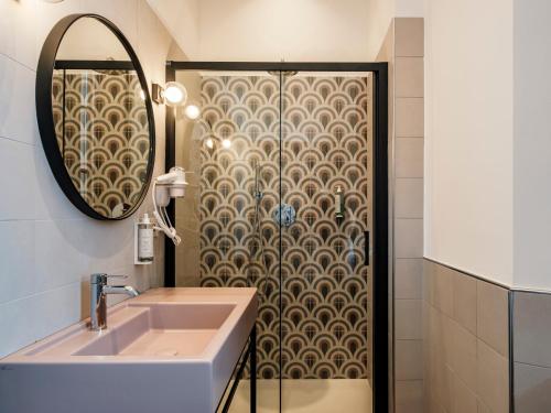 a bathroom with a sink and a mirror at Hotel Lory in Forlì