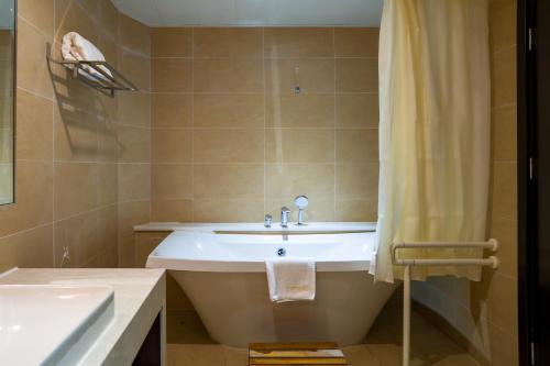a bathroom with a bath tub and a sink at Bintumani in Freetown