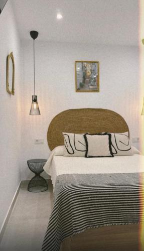 a bedroom with a large bed with a wooden headboard at La morada de Rosafina in Frigiliana