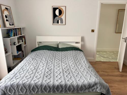 a bedroom with a bed with a gray comforter at A cozy room in family house in Dublin