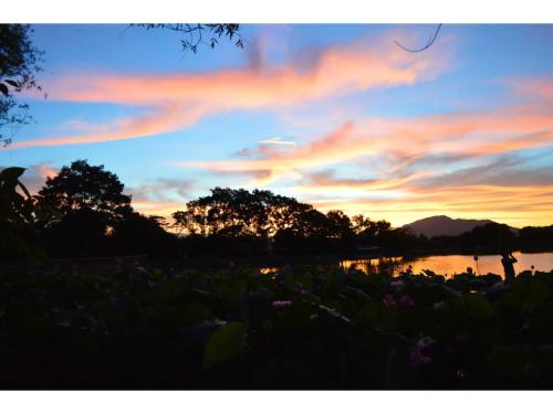 a sunset over a body of water with trees at Kisuien - Vacation STAY 55464v in Kinokawa