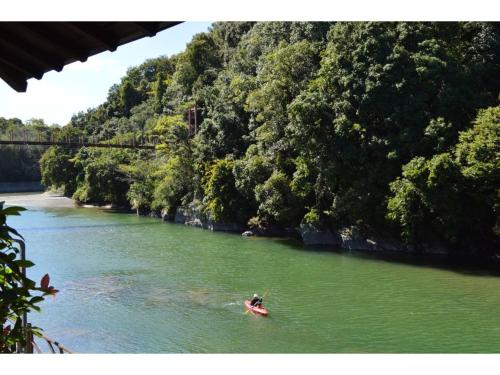 a person in a kayak in a river with trees at Kisuien - Vacation STAY 55464v in Kinokawa