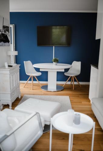 a living room with a white table and a blue wall at Exklusive Ferienwohnung mit Privatterrasse in Plön