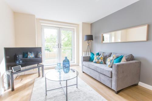 a living room with a couch and a table at Modern Comfortable 2 & 3 Bed Apartments, Free Parking, Wifi, Headington, Close to Hospitals, Science Park & Brookes University in Oxford