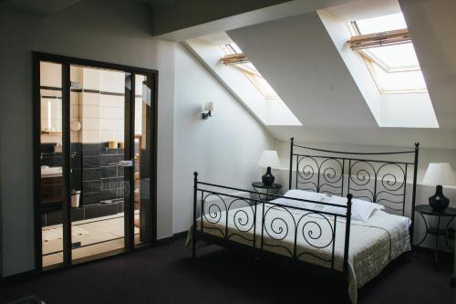 a bedroom with a black bed and a window at Kuldigas Metropole in Kuldīga