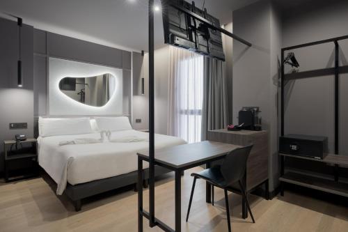 a bedroom with a bed and a table and a mirror at Hotel LIVVO La Escarlata in Las Palmas de Gran Canaria