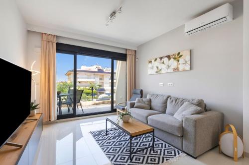 a living room with a couch and a tv at 2BD Coastal Gem with Pool & Terrace - Torre de la Horadada in Torre de la Horadada