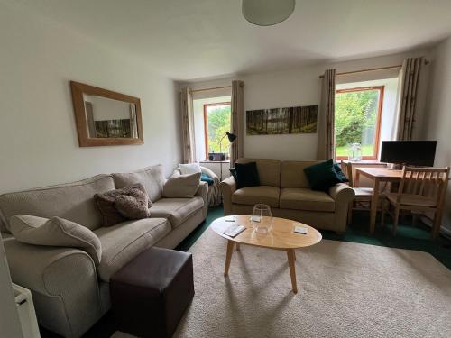 a living room with a couch and a table at Allt-Na-Craig Coach House - Ardrishaig in Ardrishaig