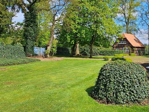 a yard with a house and a large bush at Luxuszeit zu Zweit in Borchel