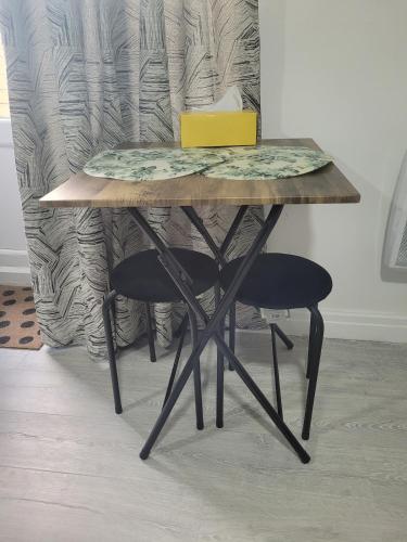 a table with a laptop sitting on top of it at Cosy newly built Self-contained garden flat in Manchester