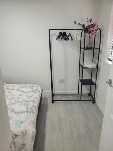 a room with a bed and a shelf with shoes at Cosy newly built Self-contained garden flat in Manchester