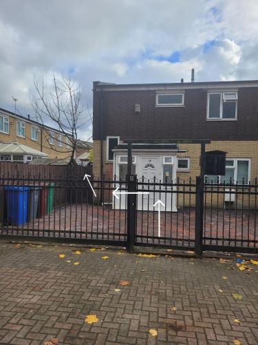 a black fence in front of a house at Cosy newly built Self-contained garden flat in Manchester