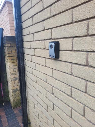 a soap dispenser on the side of a brick wall at Cosy newly built Self-contained garden flat in Manchester