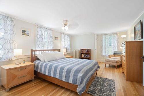 a bedroom with a bed and a chair at Main St Location Walk To Church Landing Pets in Meredith