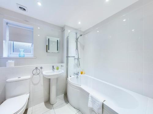 a white bathroom with a tub sink and a toilet at Modern Comfortable 2 & 3 Bed Apartments, Free Parking, Wifi, Headington, Close to Hospitals, Science Park & Brookes University in Oxford
