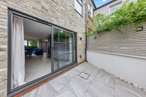 a sliding glass door in a brick building with a patio at Coach House in London