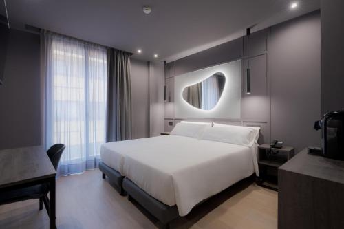 a bedroom with a large white bed and a window at Hotel LIVVO La Escarlata in Las Palmas de Gran Canaria