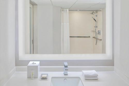 a white bathroom with a sink and a shower at Miami Airport Marriott in Miami