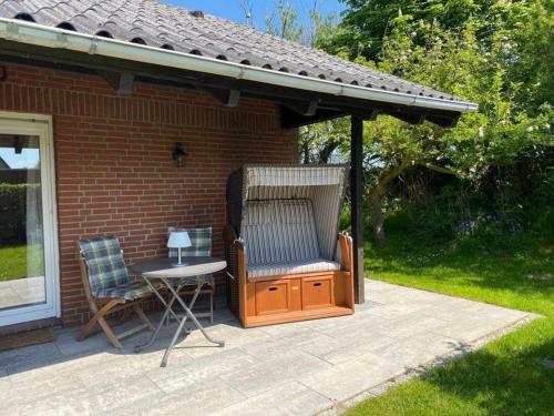 a patio with a gazebo and a table and chair at Ferienhaus De Seekobb direkt an der Nordsee in Friedrichskoog