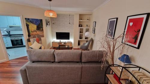a living room with a couch and a tv at En el centro, garaje privado y terraza in O Grove