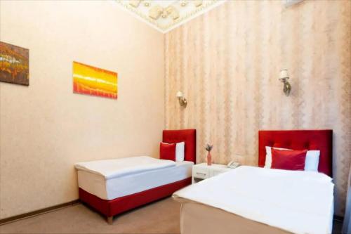 two beds in a room with red and white at Nizami Hotel Baku in Baku