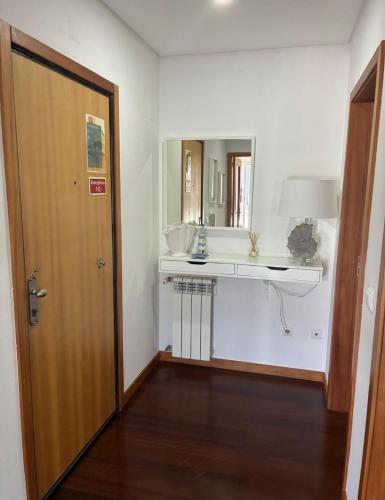 a bathroom with a sink and a mirror at Suave Mar Flat by TonsdeVerde in Esposende