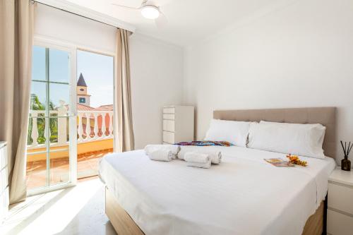 a bedroom with a large white bed and a large window at Exclusive Villa FRANJULY Playa Paraiso Ocean View Private Pool Large Terrace in Adeje