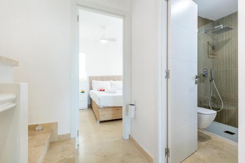 a bathroom with a shower and a toilet and a bed at Exclusive Villa FRANJULY Playa Paraiso Ocean View Private Pool Large Terrace in Adeje