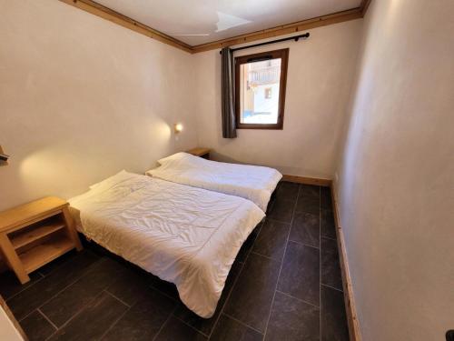 ein kleines Schlafzimmer mit einem Bett und einem Fenster in der Unterkunft Résidence Le Criterium - Résidence Le Critérium 3Chalet E Appartement 3 MAE-1913 in Les Champs