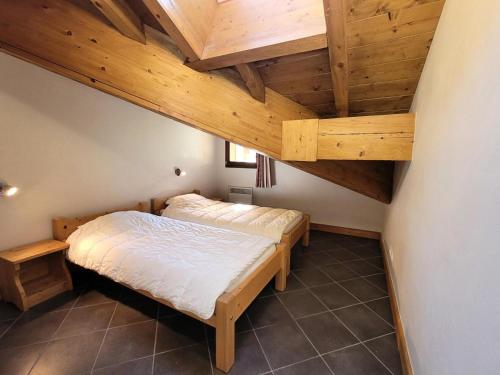 1 Schlafzimmer mit 2 Betten und Holzdecken in der Unterkunft Résidence Le Criterium - Résidence Le Critérium 3Chalet D Appartement 17 MAE-1943 in Les Champs
