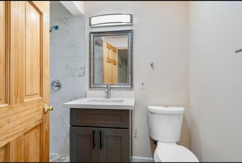 un bagno con un water, un lavandino e uno specchio di Ocean Grace in Capitol Hill a Seattle