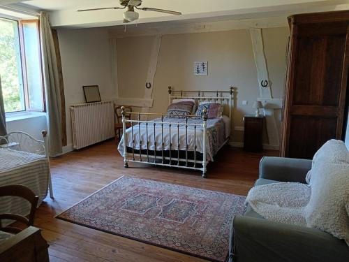 a living room with a bed and a couch at Grand logement 140m2 pour 6 personnes in Laguian-Mazoux