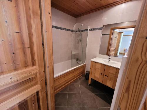 Les ChampsにあるRésidence Le Criterium - Résidence Le Critérium 3Chalet D Appartement 12 MAE-2003の浴槽と洗面台のあるバスルーム