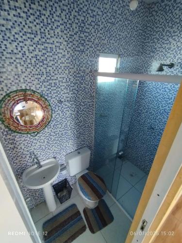 a bathroom with a toilet and a sink and a mirror at Apartamento Avenida 31 in Barreirinhas