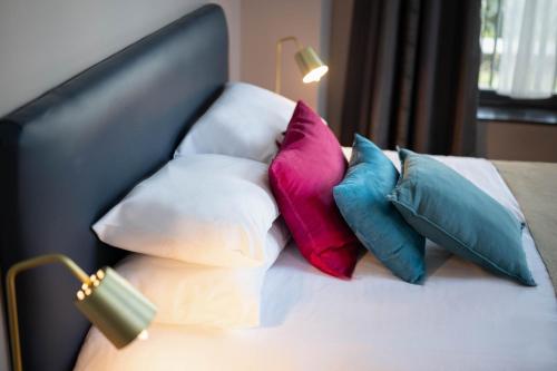 a pile of pillows sitting on a bed at Auberge du Chateau Bleu in Tremblay En France
