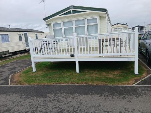 a white bench in front of a house at Willerby Delux - Holiday Home by the Sea - close to the Entertainment Complex-bedding, towels & wifi Included! in Jaywick Sands