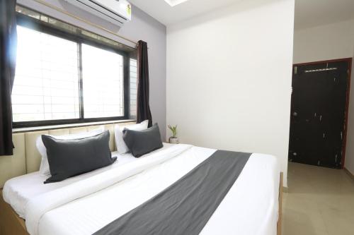 a bedroom with a large white bed with two pillows at Hotel NS Premium in Nagpur