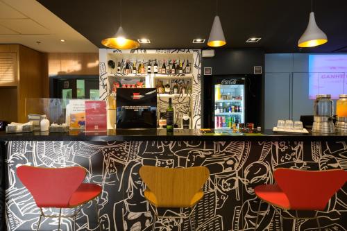 a bar with red and yellow chairs in a restaurant at ibis Aracaju in Aracaju