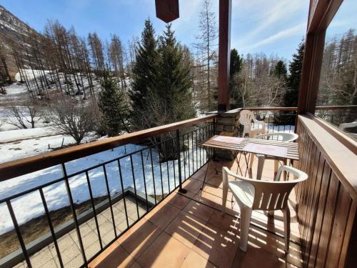 a balcony with a table and chairs and a view of the snow at Résidence Le Soliet Ii - Appartement 4 personnes lumineux et agréable MAE-2123 in Bessans