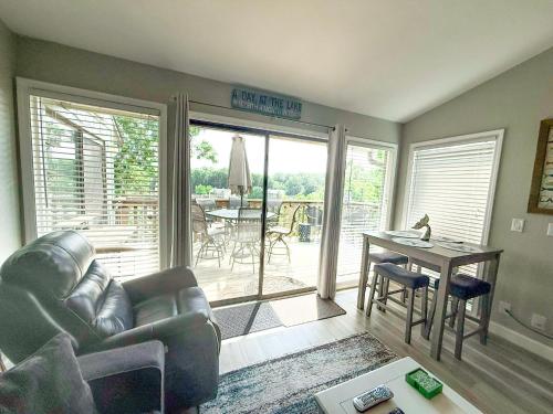a living room with a leather couch and a table and a patio at Reflections 2bd2babalconypoolshottub-4pp in Lake Ozark