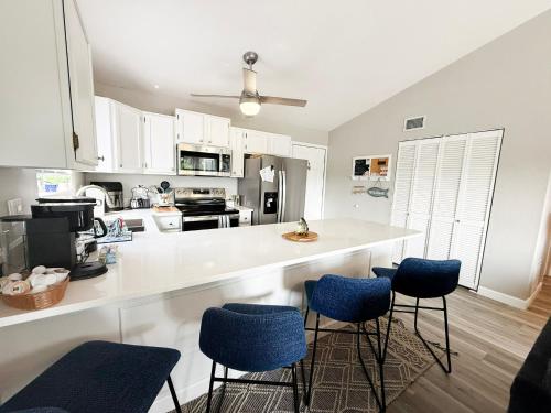 a kitchen with a white counter and blue chairs at Reflections 2bd2babalconypoolshottub-4pp in Lake Ozark