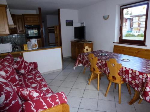 un salon avec une table et un canapé dans l'établissement Résidence Les Balcons Des Curtious - Appartement 2 pièces - 6 personnes MAE-2173, à Bessans