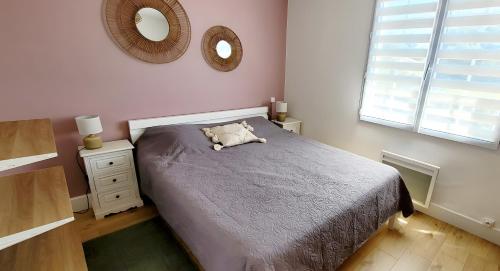 a bedroom with a bed and a mirror on the wall at Maison La Guitoune Fautaise in L'Aiguillon-la-Presqu'île