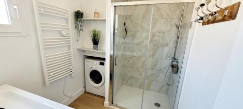 a bathroom with a shower and a washing machine at Maison La Guitoune Fautaise in L'Aiguillon-la-Presqu'île
