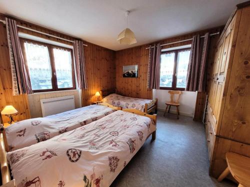 Un dormitorio con dos camas y dos ventanas. en Résidence Lanslevillard Quartier Eglise - 3 Pièces pour 6 Personnes MAE-2203, en Lanslevillard