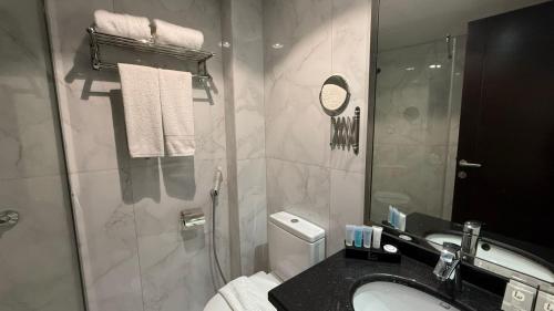 a bathroom with a toilet and a sink and a mirror at Lamar Ajyad First Hotel Tower A in Makkah