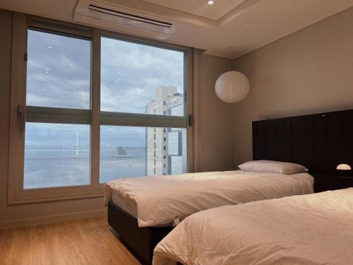 Ένα ή περισσότερα κρεβάτια σε δωμάτιο στο Bamin Stay-Gwangalli Beach Panoramic Ocean View