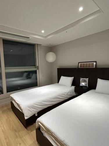 Ένα ή περισσότερα κρεβάτια σε δωμάτιο στο Bamin Stay-Gwangalli Beach Panoramic Ocean View